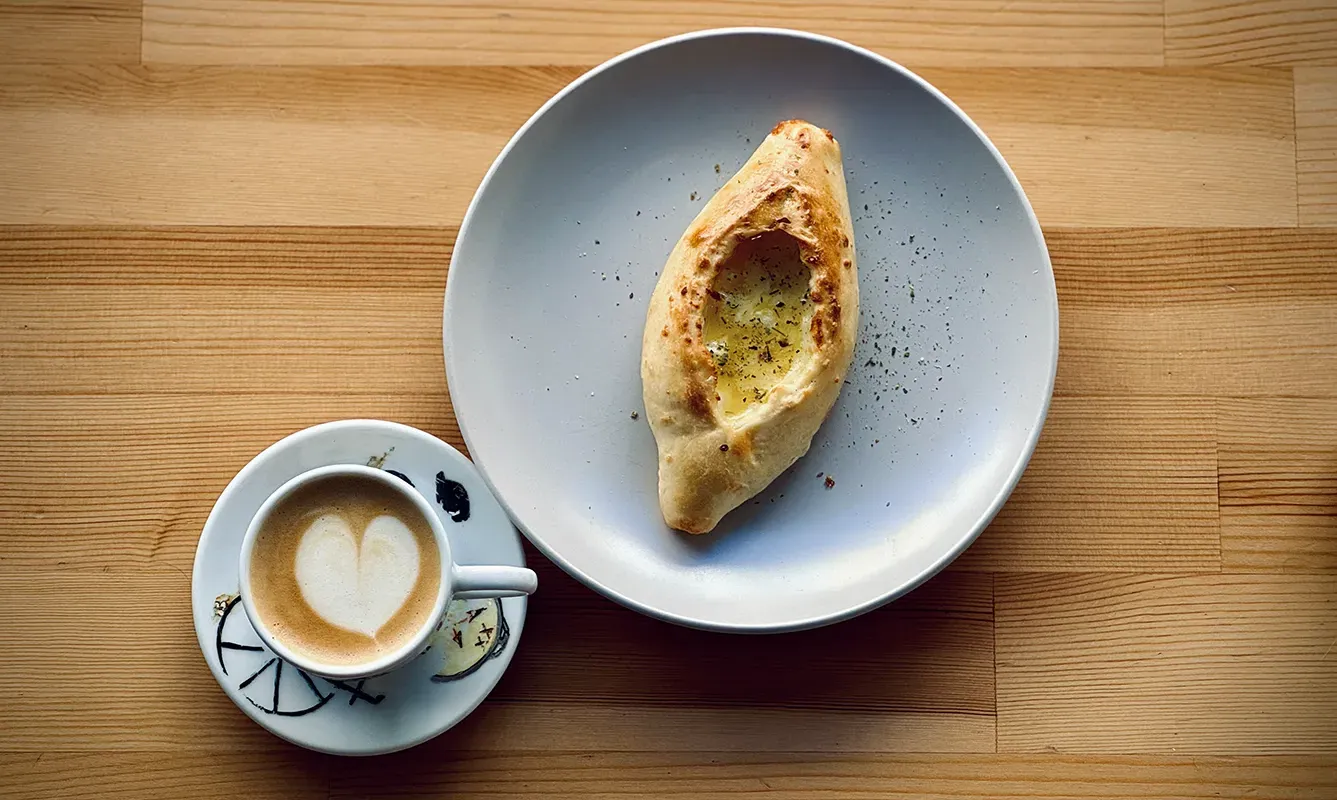 Khachapuri and coffee on a coffee shop table